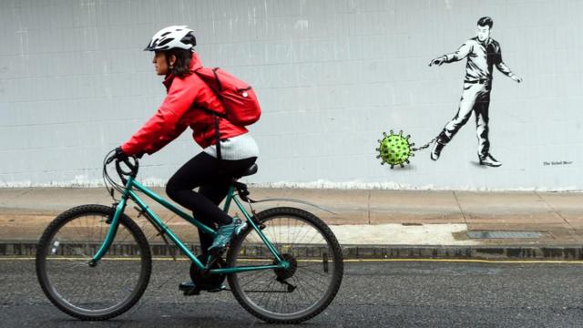 骑自行车的女子与墙上涂鸦