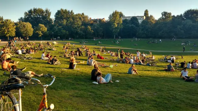 Pessoas tomam sol no parque