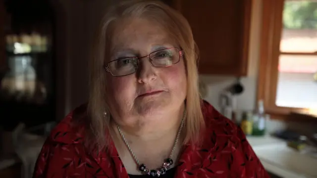 Aimee Stephens posa para foto de dentro de casa