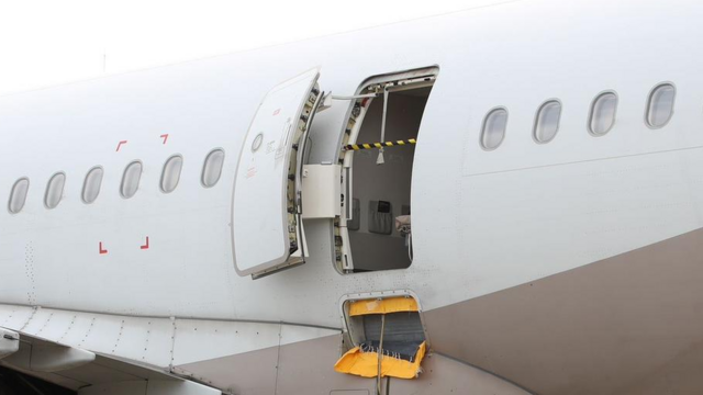 Crime scene tape covers the opened door of the plane