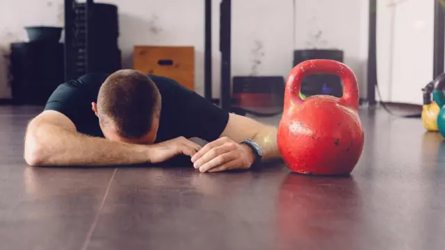 Un hombre visiblemente cansado en el gimnasio