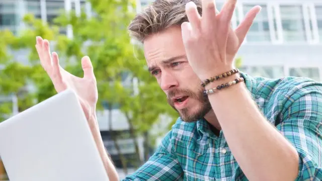 hombre sorprendido usando computadora