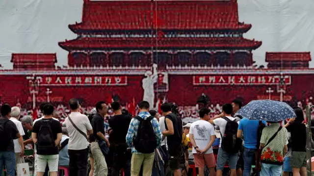 六四28周年晚会开始之前,维园群众站在象征1989年天安门广场的海报前。