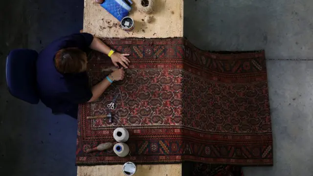 Un artesano repara una alfombra en la Real Fábrica de Tapices de Madrid