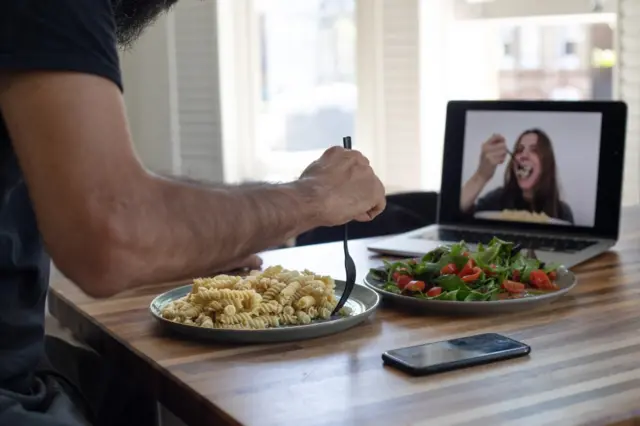 Casal comendo separado por uma telabaixar h2betcomputador