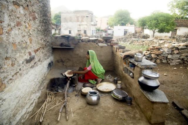Une femme au foyer faisant des chapattis dans une cuisine ouverte dans le village de Delwara, Udaipur, Rajasthan, Inde.