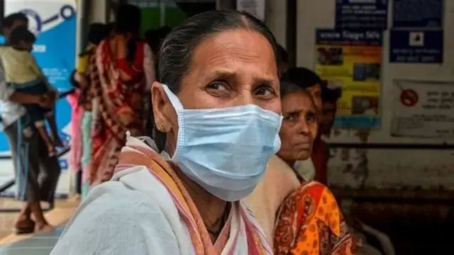 ਕੋਰੋਨਾ ਵਾਇਰਸ,ਮਾਸਕ ਨਾਲ ਮੂੰਹ ਢਕੀ ਬੈਠੀ ਔਰਤ