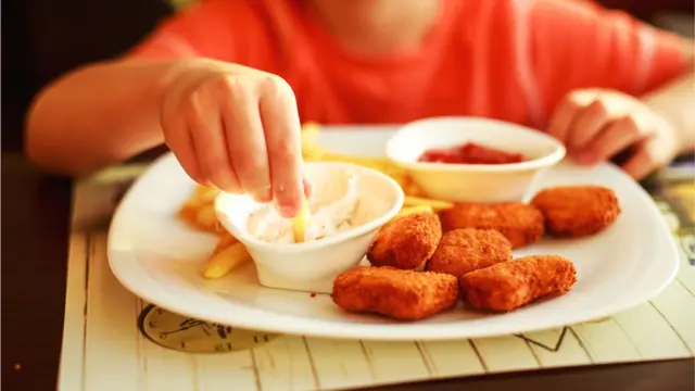 Niño comiendo nuggets de pollo