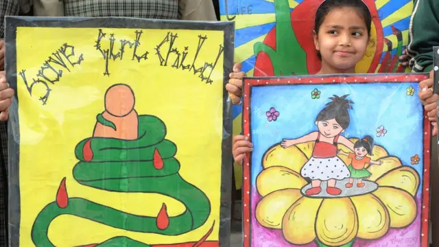 প্ল্যাকার্ড হাতে কন্যা শিশু