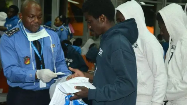 People stand in front of immigration officer