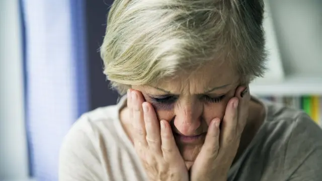 Una mujer se agarra la cara