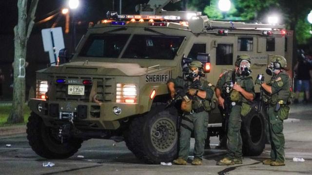 美国威斯康辛州基诺沙市数名县警防暴人员在一辆装甲车旁戒备（24/8/2020）