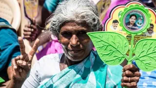 இரட்டை இலை சின்னத்தோடு பெண்ணொருவர்