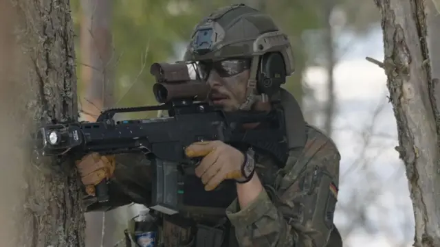 Un soldado con un rifle, en uniforme de camuflaje 