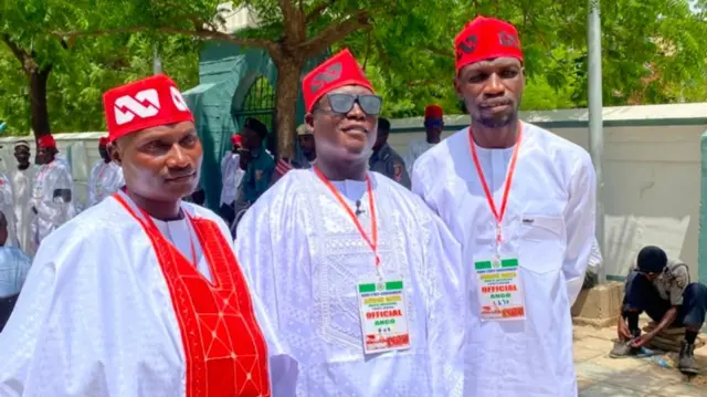 Three men wear white and red cap