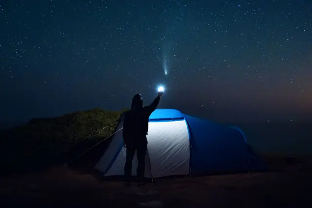 Homem olha cometa no céu