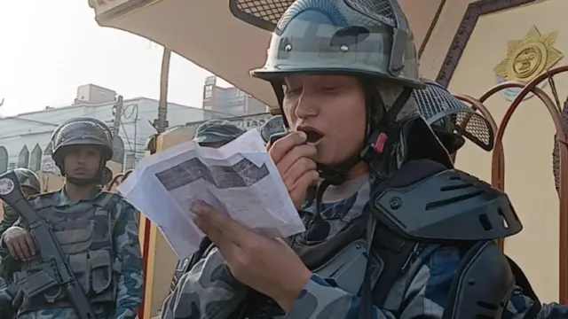 वीरगन्जमा माइकिङ्गमार्फत कर्फ्यूको जानकारी दिदैँ एक महिला सुरक्षाकर्मी।