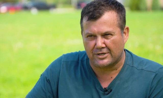 Charl Kleinhaus mavi tişörtü ile yeşil bir arka planda BBC'ye röportaj veriyor.
