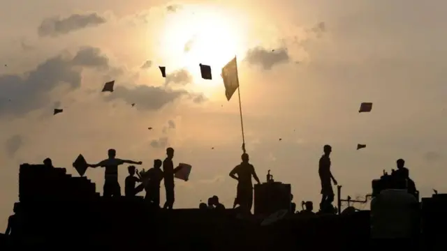 ljudi puštaju zmajeve u sumrak