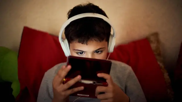 یک کودک در حال بازی با موبایل 