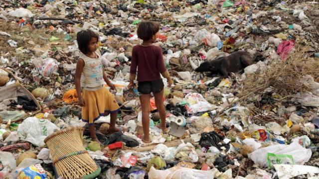 Indian child rag pickers search for recyclable materials at a garbage dump area in Noida on May 14, 2018.