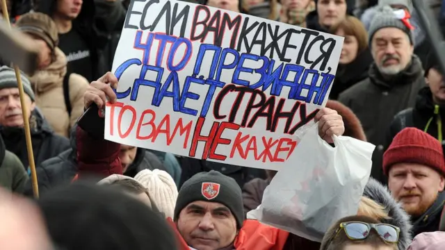 Мужчина держит плака против интеграции Беларуси с Россией