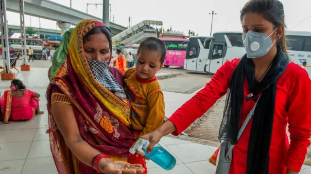 સૅનિટાઇઝર આપતા યુવતી