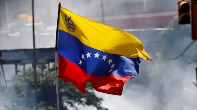 A demonstrator waves a Venezuelan flag during riots at a march to state Ombudsman"s office in Caracas, Venezuela May 29, 2017.