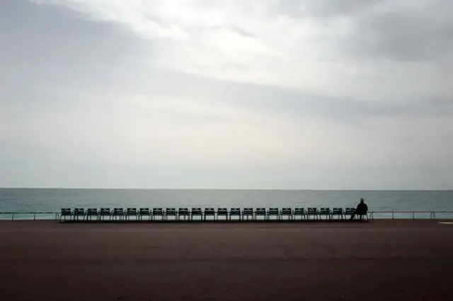 Um homem observa o mar Mediterrâneopixbet 2024Nice, na França,pixbet 2024março