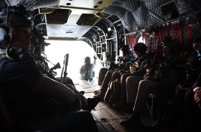 Secret Service counter-assault team members, accompanying US President Donald Trump in another helicopter, ride in the back of a helicopter as they attempt to fly to the Demilitarized Zone (DMZ) over Seoul, South Korea on November 8, 2017. The crew was forced to turn around before landing due to bad weather. US President Donald Trump was forced to abandon an attempted surprise visit to the Demilitarized Zone that divides the two Koreas due to bad weather, a pool report said. The US head of state, who the White House had previously said would not go to the symbolic spot, left his hotel in Seoul early in the morning and went to the Yongsan military base in the city, but a helicopter flight to the DMZ had to be called off due to weather conditions. / AFP PHOTO / JIM WATSONJIM WATSON/AFP/Getty Images