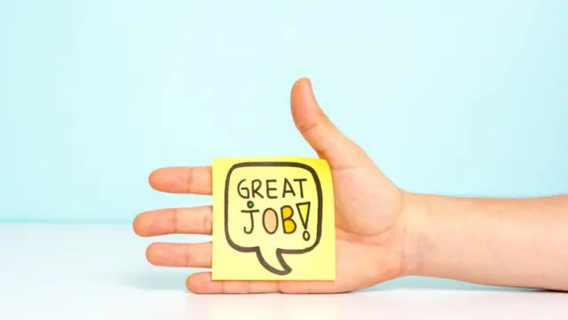 Hand dey hold a Post-it note