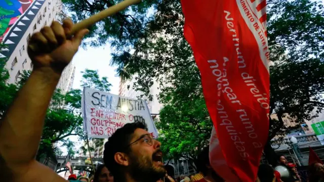 أعضاء من الحركات الاجتماعية يحتجون دفاعاً عن الديمقراطية في بورتو أليغري، جنوب البرازيل، في 9 يناير/ كانون الثاني 2023، بعد يوم من غزو أنصار الرئيس البرازيلي اليميني المتطرف جاير بولسونارو الكونغرس والقصر الرئاسي والمحكمة العليا في برازيليا.