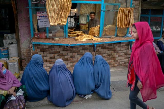 কাবুলে এক রুটির দোকানের সামনে রুটির অপেক্ষায় তিন আফগান নারী। বহু মানুষ এখন খাদ্য সংকটে আছে।