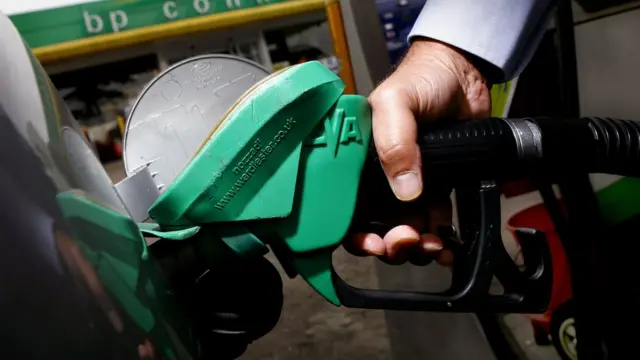 رجل يزود سيارته بالوقود في محطة تابعة لبريتيش بتروليوم في لندن.