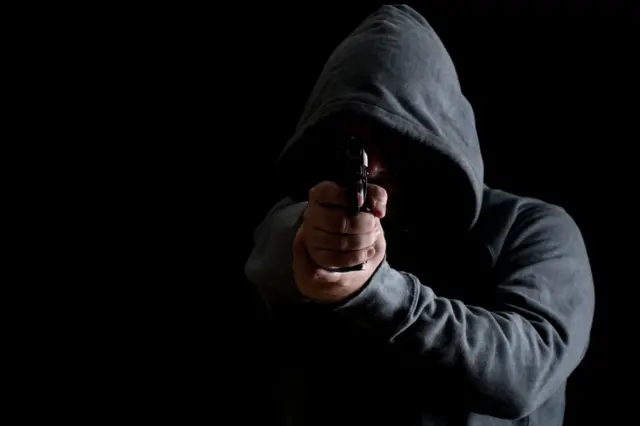 Hombre apuntando con un arma