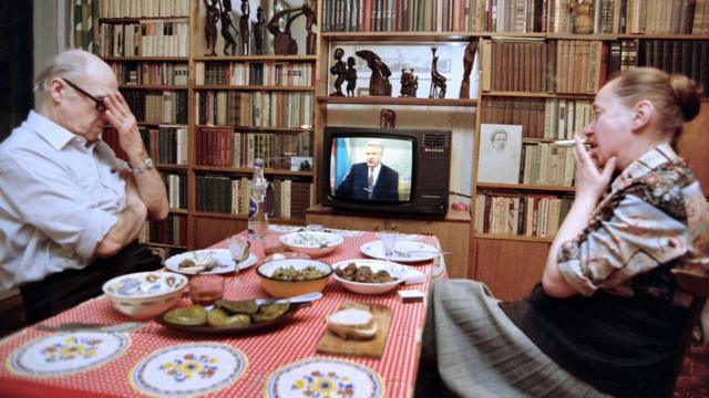 Москвичи Юрий и Елена Пудаловы смотрят обращение Бориса Ельцина к народу. Март 1993 года, на столе маринованные огурцы и колбаса.