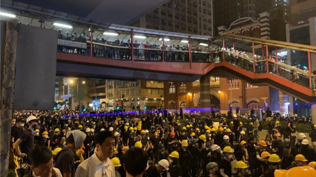 上环冲突现场，示威者有数百人。 其中一些人开始向警察投掷头盔和雨伞。