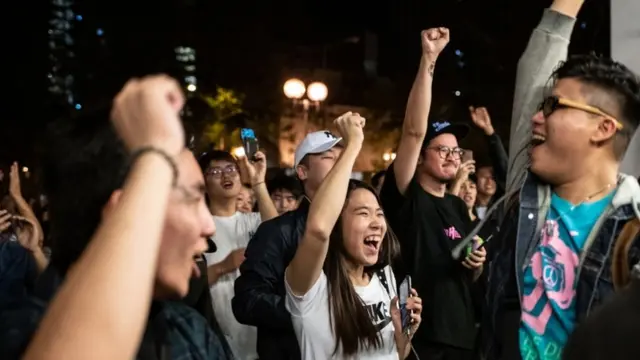 Pro-democracy supporters chant as they celebrate after pro-Beijing candidate Junius Ho lost a seat in the district council elections in Tuen Mun district of Hong Kong