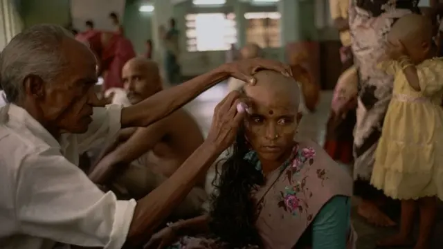 Мужчина обривает голову женщине