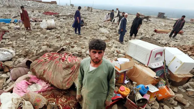 An Afghan man joins a group of people searching for their belongings