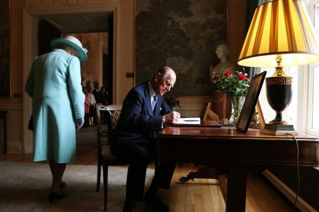 2014年，他陪同女王參觀了北愛爾蘭。圖為他在貝爾法斯特的希爾斯伯勒城堡在訪客留言本上簽字留言。
