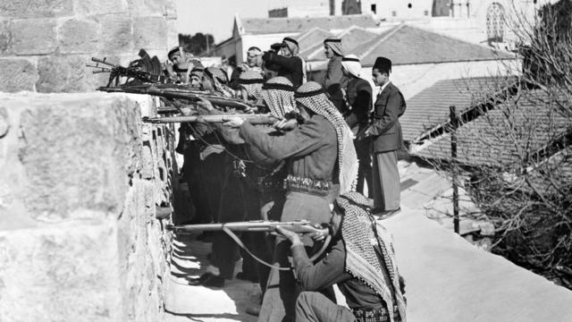 Os soldados das forças aliadas da Legião Árabe atiram, em 06 de março de 1948, do setor leste de Jerusalém, sobre os combatentes judeus da Haganah, a força de autodefesa da Agência Judaica, sediada no bairro de Jemin Moshe do setor oeste da cidade durante o primeiro conflito árabe-israelense