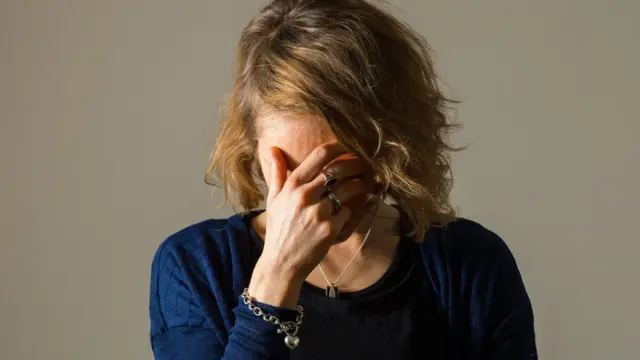 หญิงสาวกุมใบหน้า