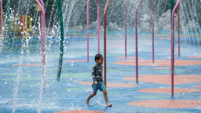 Хлопчик йде між фонтанами