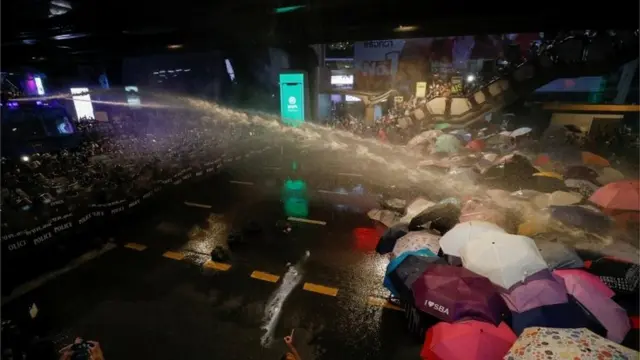 People are hit with water from water cannons during an anti-government protest, in Bangkok, Thailand October 16, 2020.
