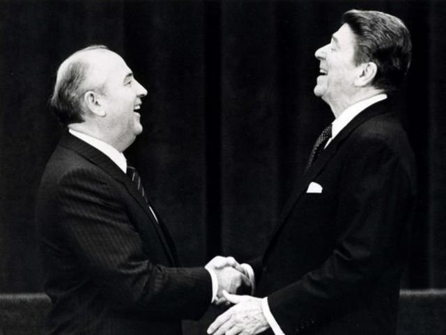戈尔巴乔夫与美国总统里根握手。苏联与美国关系缓和，冷战走向结束。