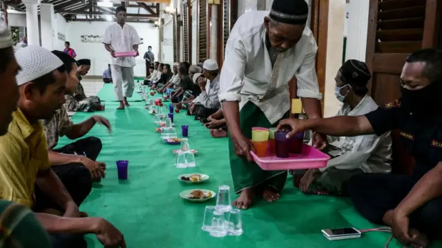 Residents Iftar together at An-Nawier Mosque on the first day of Ramadan during a large-scale social restriction (PSBB) as preventive measures for the spread of the coronavirus (COVID-19) in Jakarta, Indonesia