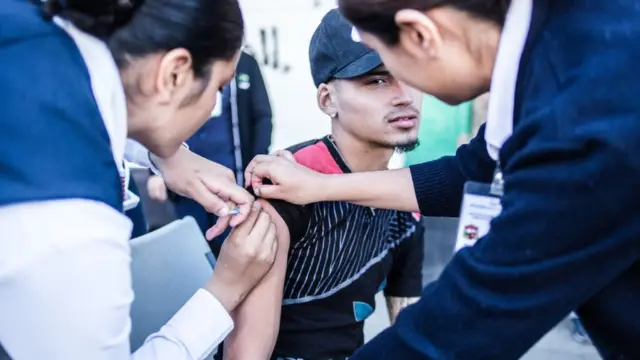 Un joven recibe una vacuna en el brazo