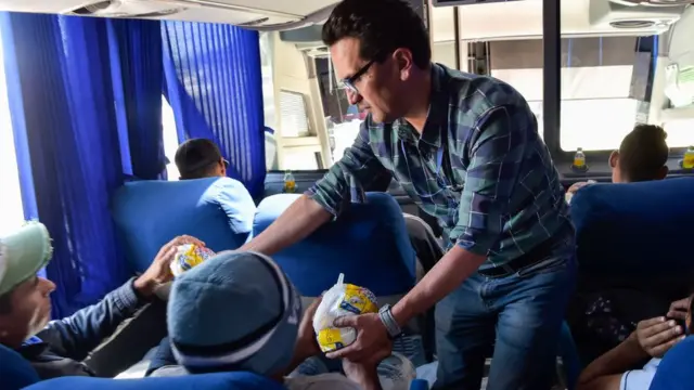 Benévolo repartiendo comida en un bus.