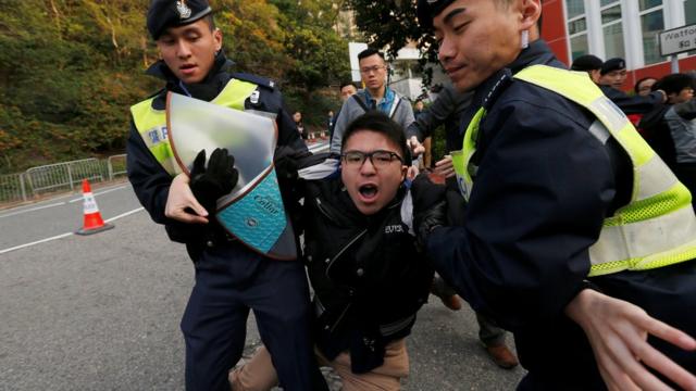 A pro-democracy protester against the disqualification of lawmakers is taken away by the police before Hong Kong Chief Executive Carrie Lam arrives to vote during a Legislative Council by-election in Hong Kong, China March 11, 2018. REUTERS/Bobby Yip